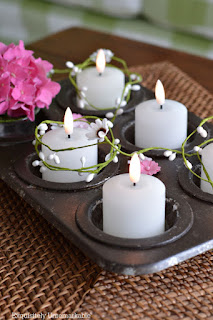 Dollar Tree Cupcake Tin Makeover with votives and flowers in each cup and garland wrapped around it